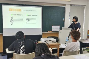 通信制高校　授業　スクーリング　教員　先生　生徒　黒板　プロジェクター　投影　音楽　音符
